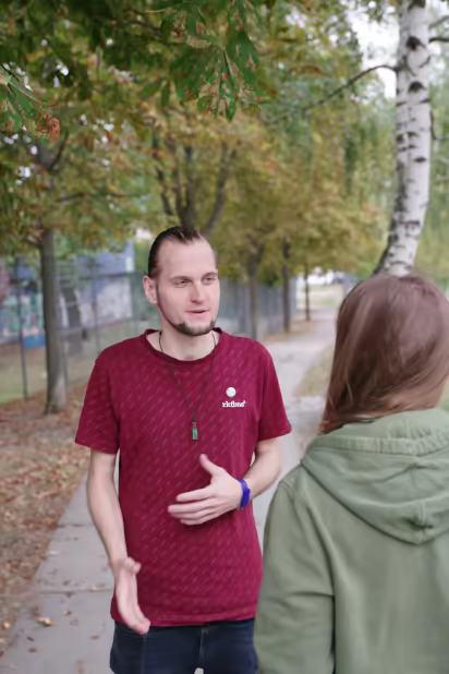 ich, mit zusammengebundenen Haaren, im Gespräch mit einer Person